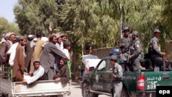 FILE : Men transport the bodies of four civilians killed in an airstrike in Kandahar in 2009.