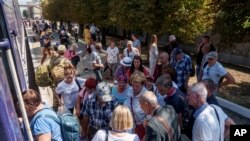 Oamenii stau la coadă pentru un tren de evacuare din Pokrovsk, regiunea Donețk. 19 august 2024.