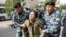 KAZAKHSTAN -- Kazakh law enforcement officers detain a woman during a rally held by opposition supporters in Nur-Sultan, September 21, 2019