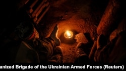 Ілюстраційне фото. Військовослужбовець 24-ї механізованої бригади ЗСУ імені короля Данила гріє ноги за допомогою окопної свічки в окопі поблизу міста Часів Яр у Донецькій області, Україна, 25 жовтня 2025 року