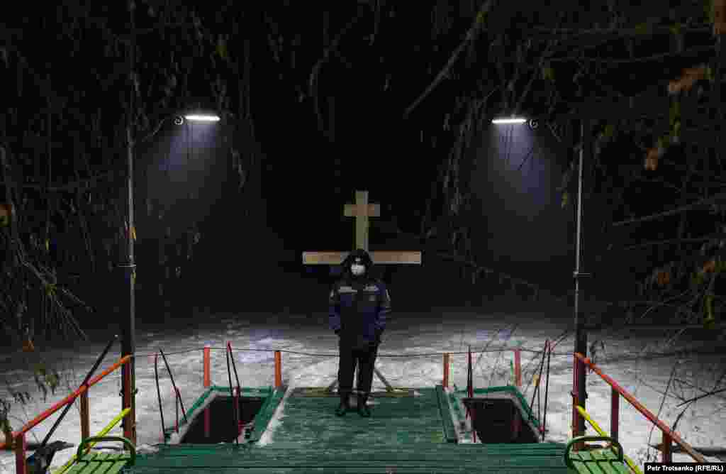 A man stands guard over the holes in the ice in Almaty, Kazakhstan.