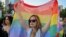 پرچم رنگین‌کمانی در دست یکی از حامیان جامعهٔ دگرباشان