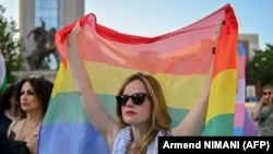 پرچم رنگین‌کمانی در دست یکی از حامیان جامعهٔ دگرباشان