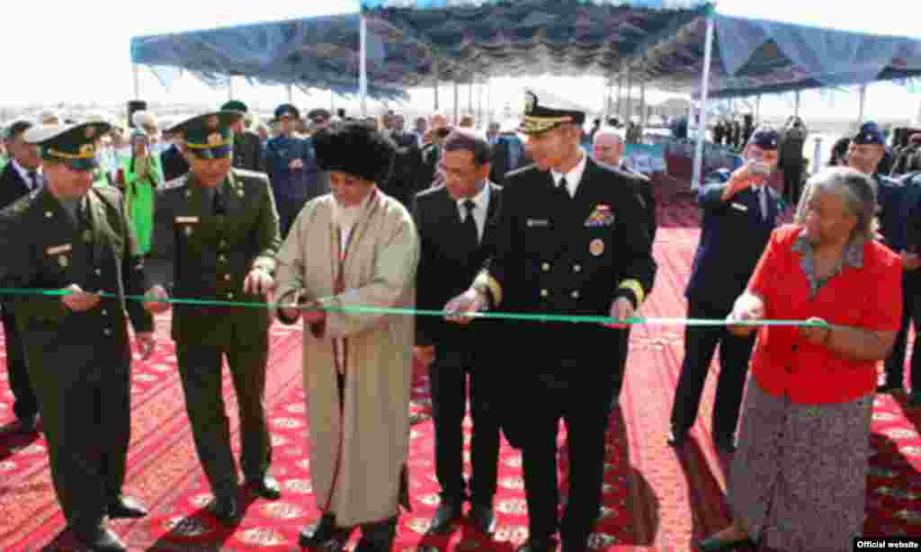 Resmi adamlar serhet geçelgesiniň açylyş dabarasynda ýaşyl lentany kesýärler 