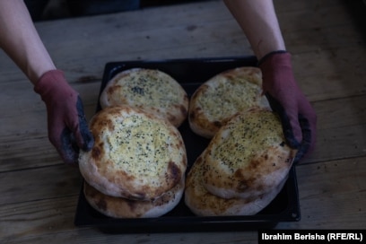 Bukëpjekësi në furrën "Isufi" në Prizren palos pitalkat në një tepsi para se t’ua shesë myshterinjve.Furra, e udhëhequr nga vëllezërit Hajdari, mburret me një traditë rreth 200-vjeçare.
