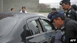 Police officials inspect the bullet-riddled car of Minorities Minister Shahbaz Bhatti following the deadly attack in Islamabad on March 2.