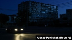 Автомобиль едет по темной улице во время временного отключения электроэнергии, вызванного атаками ВСУ. Евпатория, аннексированный Крым, июль 2026 года