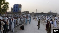 Pakistani IDPs (internally displaced persons) from the North Waziristan region gather outside of the World Food Program food-distribution point in Bannu on June 24.