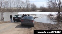 Қызылжар ауданының Новоникольск ауылында су басқан көпірден өте алмай тұрған тұрғындар. Солтүстік Қазақстан облысы, 20 сәуір 2018 жыл.