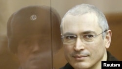 Mikhail Khodorkovsky stands in the defendants' cage before the start of a court session in Moscow on December 28.