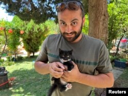 Jurnalistul Issam Abdallah de la Reuters, surprins cu o pisică în brațe, în Saaideh, Liban, pe 4 iulie 2023.