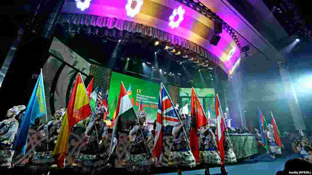 Performers hold the flags of the 27 countries participating in the festival.