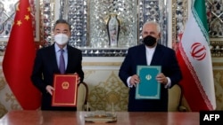 Міністр закордонних справ Ірану Мохаммад Джавад Заріф (праворуч) та його китайський колега Ван І після підписання угоди і іранській столиці. Тегеран, 27 березня 2021 року
