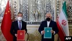 Ministri i Jashtëm i Kinës, Wang Yi, dhe ministri i Jashtëm i Iranit, Mohammad Javad Zarif, duke nënshkruar një marrëveshje në Teheran, më 27 mars, 2021.