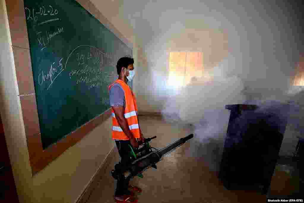 A Pakistani health worker disinfects a classroom before the reopening of educational institutions in Karachi on September 10. (epa-EFE/Shahzaib Akber)