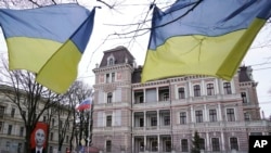 Державні прапори України майорять навпроти будівлі посольства Росії в Ризі, Латвія, 24 січня 2023 року