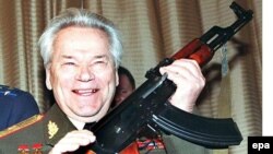 Arms designer General Mikhail Kalashnikov holds his iconic "Kalashnikov" assault rifle during celebrations in 1997 of the 50th anniversary of the first-version AK-47.